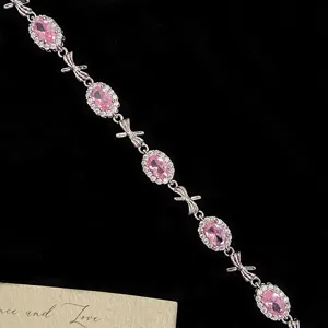 Sweet French style silver bracelet featuring pink oval gems and delicate bow links