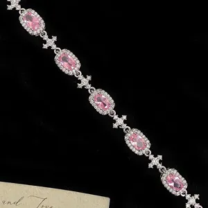 Elegant silver chain bracelet featuring oval pink gemstones and sparkling cross charms.
