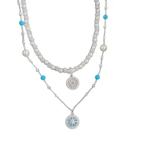 Luxueux collier boussole bleu à plusieurs rangs avec perles blanches et pendentifs en zircon.