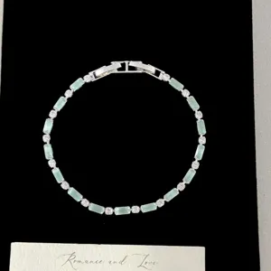Gros plan d'un élégant bracelet avec des zircons rectangulaires vert givré étincelant