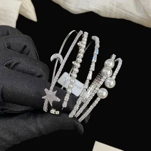 Primo piano di eleganti braccialetti color argento con perle e ciondoli a stella