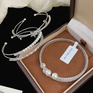 Vista dettagliata di eleganti bracciali argentati con dettagli di stelle lune e perle