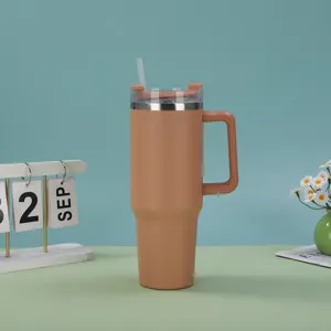 Close-up of 40oz insulated stainless steel tumbler with handle and straw in orange