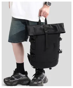 Detailed view of black waterproof roll-top backpack held by model showing scale