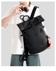 A male model wearing a black large capacity roll-top business laptop backpack outdoors.
