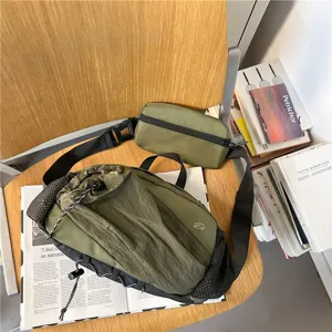 Detailansicht der olivgrünen Outdoor-Brusttasche und des Beutelsets auf einem Holzstuhl