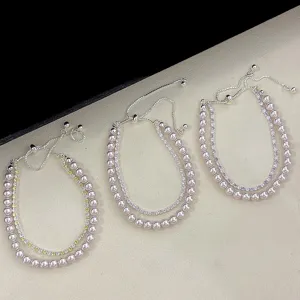 Tres elegantes pulseras de doble capa con perlas y circonitas de colores sobre fondo texturizado.