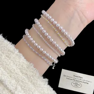 Detalle de elegantes pulseras de perlas y circonitas de colores puestas en la muñeca del modelo