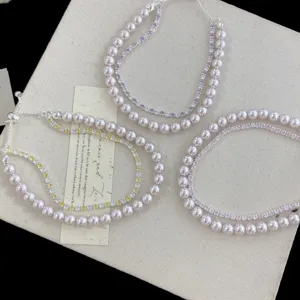 Vista detallada de una elegante pulsera de doble capa con perlas rosas y circonitas