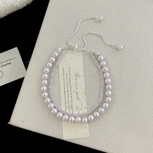 Detalle de la elegante pulsera de doble capa con circones rosas y perlas falsas