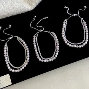 Vista detallada de pulseras de doble capa con perlas y circonitas y cierre ajustable