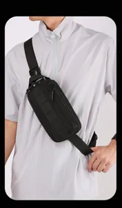 Dettaglio ravvicinato di una borsa da petto nera e funzionale con cinghie tattiche e zip.