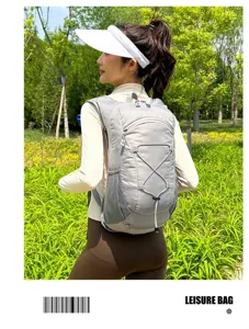 Back view of a lightweight grey outdoor cycling backpack worn by a model in a park.
