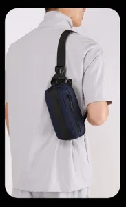 Vista dettagliata della borsa da petto funzionale blu scuro indossata a tracolla con cinghie regolabili.