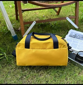 Detailansicht der gelben Sporttasche auf Gras mit Outdoor-Lifestyle-Requisiten