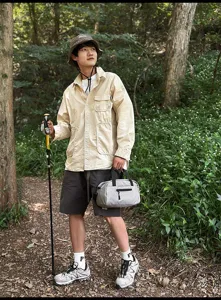 Detailansicht einer grauen Sport-Umhängetasche, getragen von einem Wanderer im Wald
