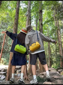 Pärchen trägt minimalistische japanische Umhängetaschen in einer grünen Waldkulisse