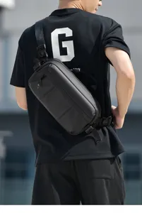 Rear view of a black waterproof sling bag worn by a model in an urban setting.