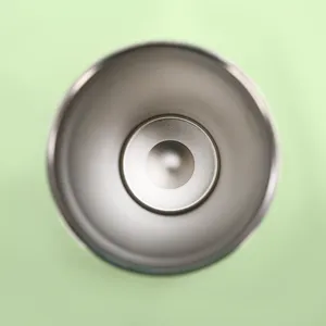 Stainless steel tumbler interior detail shot, 304 insulated cup inner view, green background.