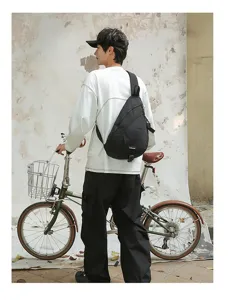 Mann trägt eine schwarze Nylon-Umhängetasche neben einem Vintage-Fahrrad im Detail