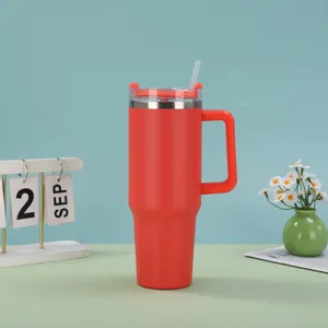 Red 40oz insulated stainless steel tumbler with handle and straw in lifestyle setting