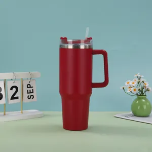 Red 40oz insulated stainless steel tumbler with handle and straw, side view on desk