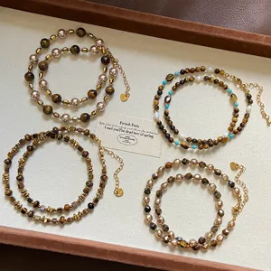 Handcrafted tiger eye stone necklaces displayed on a beige vintage jewelry tray
