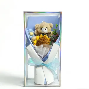 Handmade crochet sunflower and cute teddy bear bouquet in transparent gift box detail view.