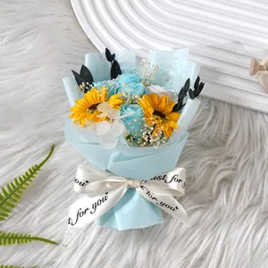 Mini Kunstblumenstrauß mit blauen Rosen und Sonnenblumen als Geschenk Dekoration Detail.