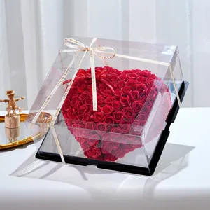 Caja de regalo romántica en forma de corazón con rosas rojas y cubierta transparente.