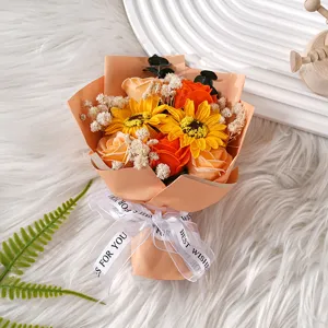 Nahaufnahme des künstlichen Blumenstraußes mit Sonnenblumen und Rosen in Orangenpapier.