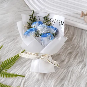 Detailansicht eines charmanten blauen Rosenstrausses mit weisser Verpackung zum Valentinstag.