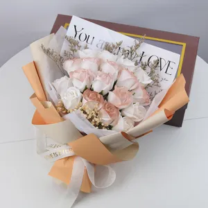 Primer plano de un ramo de rosas de jabón color melocotón y blanco con flores de paniculata