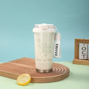 Détail du tasse à café isotherme en acier inoxydable avec motif de lys et sangle.