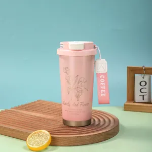 Vue détaillée d'une tasse thermique en acier rose, avec motif floral et sangle pratique.