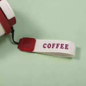 Gros plan de détail d'une lanière de tasse isotherme portable avec impression de texte.