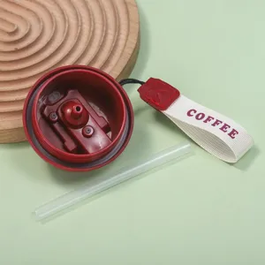 Vue détaillée du couvercle rouge de tasse thermos, de la paille et de la sangle pratique.