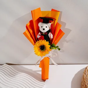 Nahaufnahme des Abschluss-Sonnenblumen- und Bären-Blumenstraußes in orangefarbenem Papier.