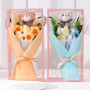 Nahaufnahme von zwei handgefertigten Häkelblumensträußen mit Teddybären in rosa Geschenkboxen