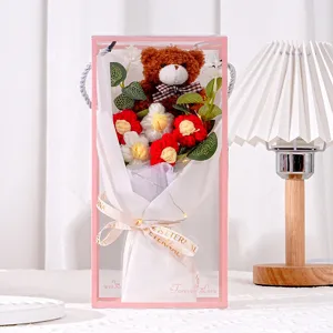Nahaufnahme eines handgehäkelten Blumenstraußes mit Teddybär in einer Geschenkbox