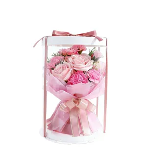 Élégant bouquet de roses en savon rose dans une boîte cadeau cylindrique transparente