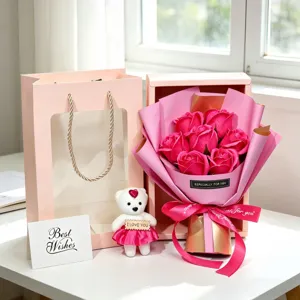 Detail view of a pink 7-rose soap flower gift box with small bear and matching gift bag.