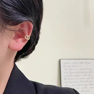 Detailed view of a sparkling gold-plated pig nose ear cuff featuring pavé rhinestones