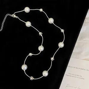 Close-up detail of an elegant pearl necklace featuring metallic beads on black velvet