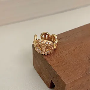 Detailed view of a gold-toned ear cuff featuring sparkling crystal pavé in a CD design