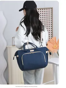 Modella con borsa fasciatoio blu scuro dotata di pregiati manici in pelle scura