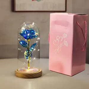 Dettaglio di rosa blu in foglia d'oro sotto campana di vetro con luci LED