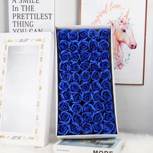 Detailansicht von leuchtend blauen dreilagigen Seifenrosen in einer weißen Geschenkbox