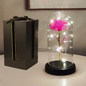Rosa rosa incantata in cupola di vetro con luci LED e una confezione regalo nera elegante