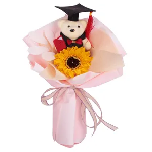 Detail view of a graduation plush bear bouquet with a bright sunflower and pink wrapping.